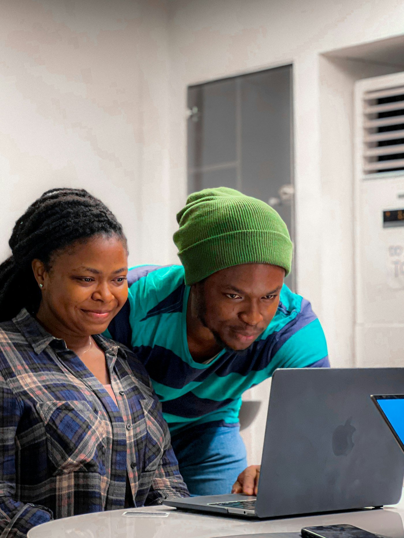 Two young African Fellows working together at a laptop