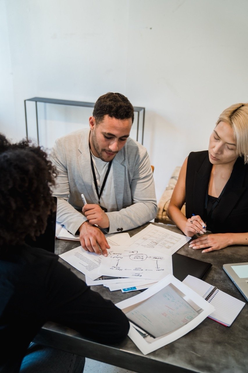 A group of people around a table reviewing documents together